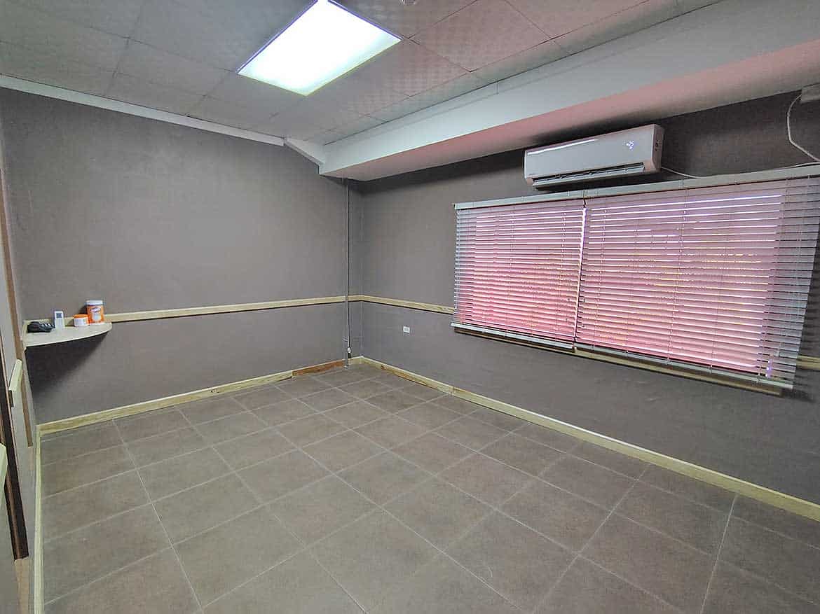 Interior Office Space at e TecK Building Cornerstone- Empty office room with gray walls, window blinds, and air conditioning unit.