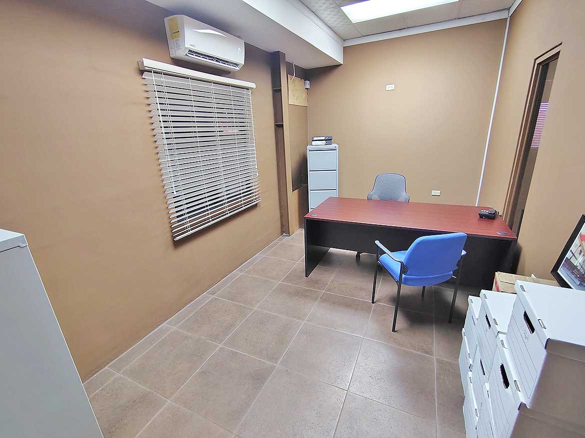 Office Space at e TecK Building Cornerstone- Interior of an office with desk, chairs, and air conditioning unit.