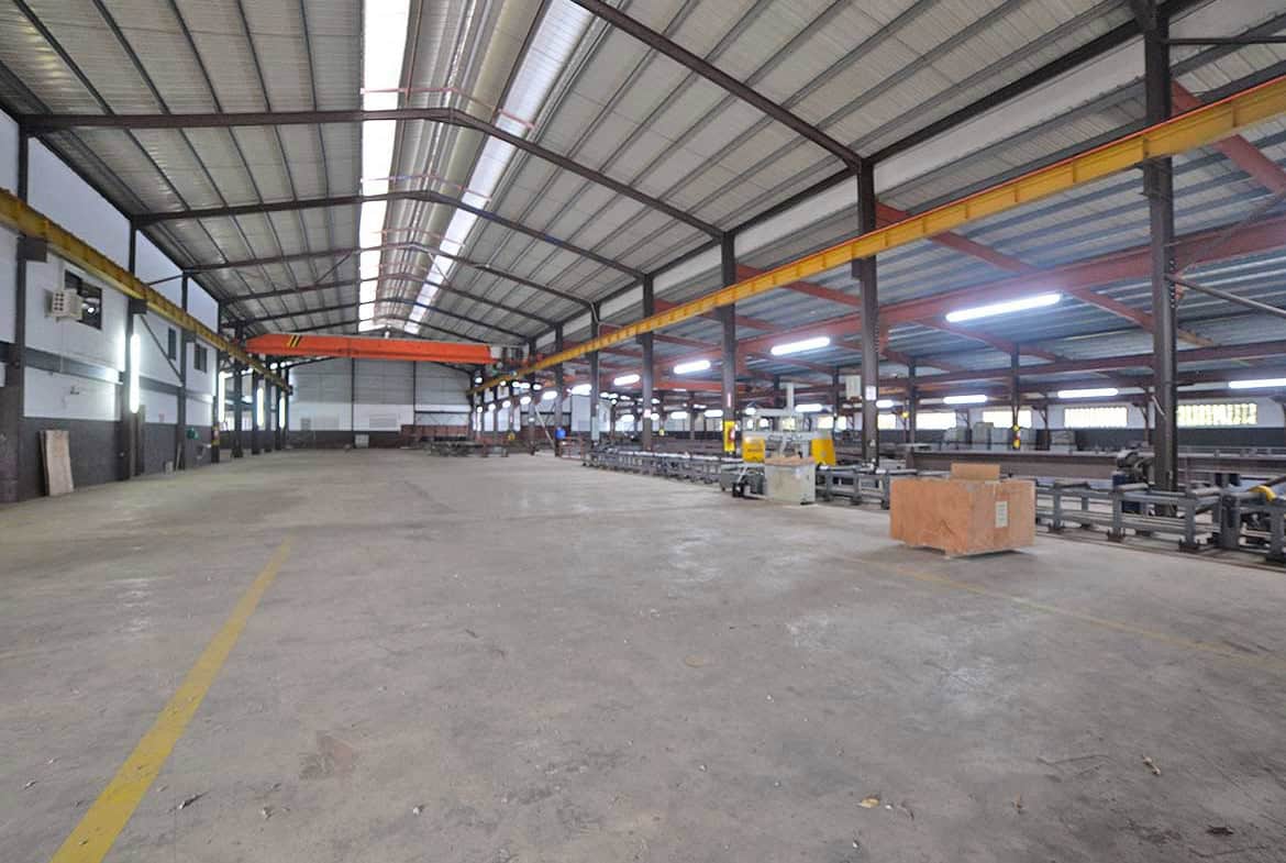 Cornerstone- Spacious industrial warehouse with overhead crane system and metal roof.