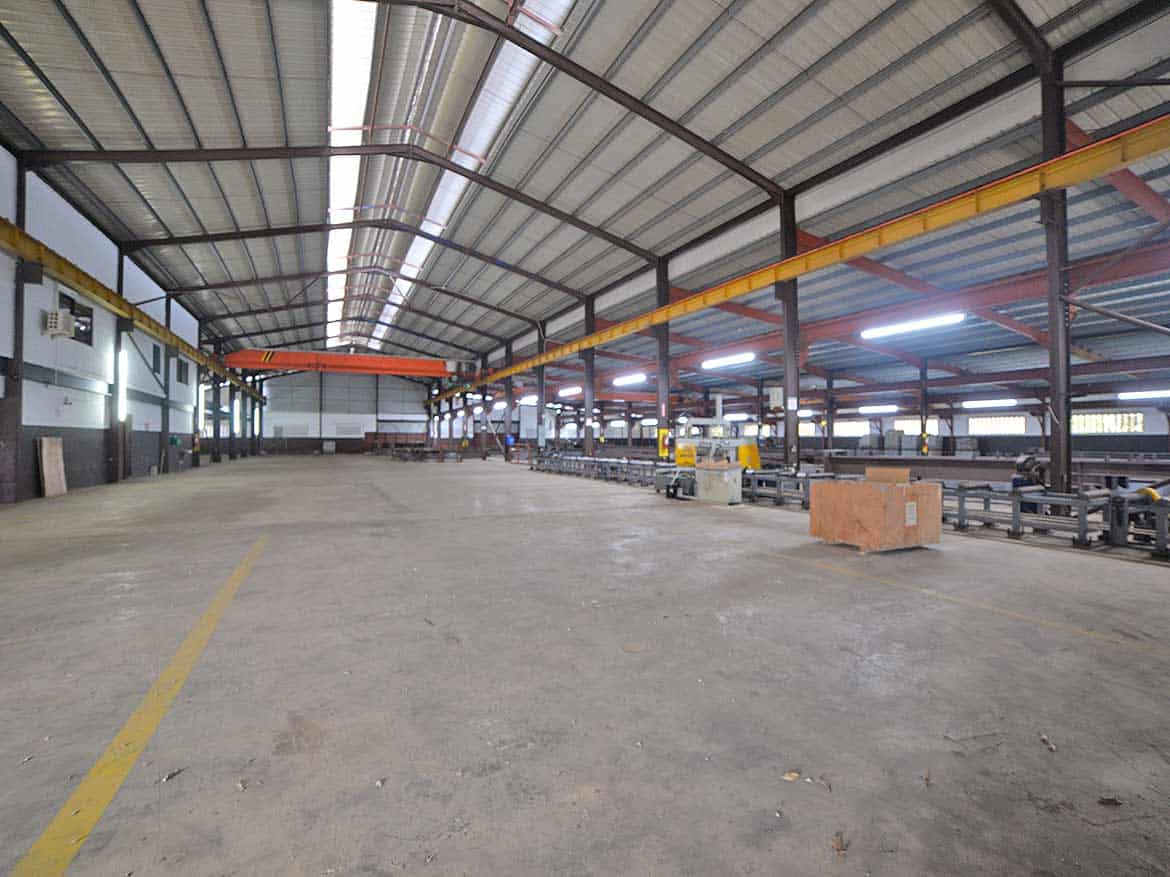e TecK Building Interior Cornerstone- Spacious industrial warehouse with overhead crane system and metal roof.