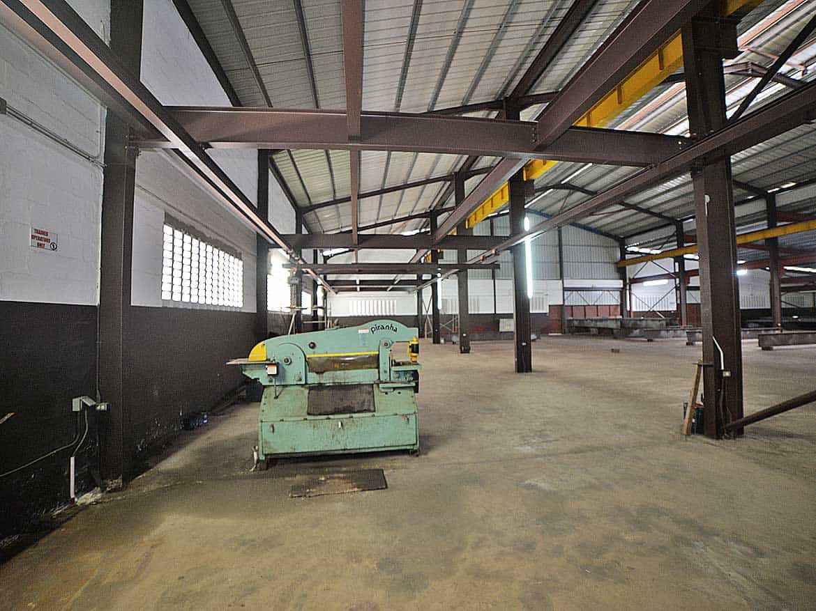 Industrial Warehouse at e TecK Building Cornerstone- Spacious industrial warehouse interior with machinery and steel framework.
