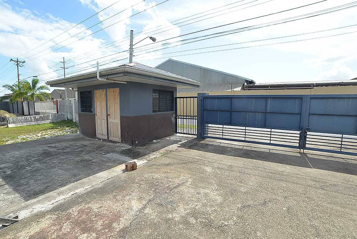 Cornerstone- Small building with blue gate at O'Meara e TecK site in Trinidad.