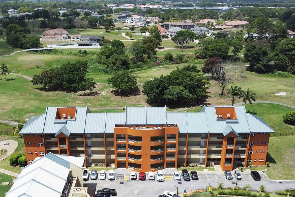 Aerial view of Cornerstone™ residential building with parking lot and green landscape.
