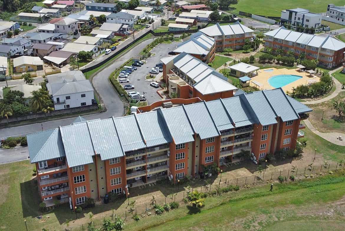 Aerial view of EastGate on the Greens residential apartments with pool and surrounding neighborhood.