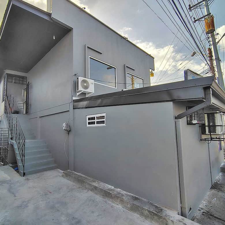 Cornerstone- Modern commercial building in Curepe with gray exterior and stairs.