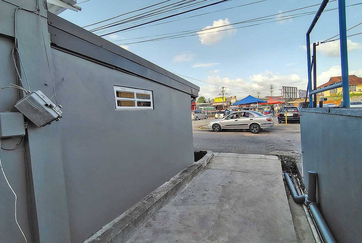 Cornerstone- Outdoor view of commercial space in Curepe with parking and street scene.