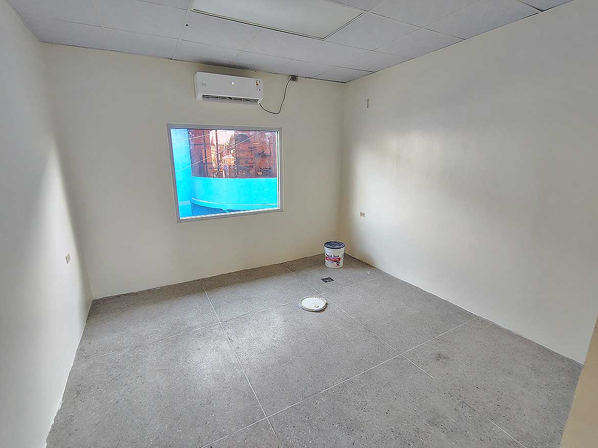 Commercial Space Interior in Curepe Cornerstone- Empty commercial room with window and air conditioning unit in Curepe.