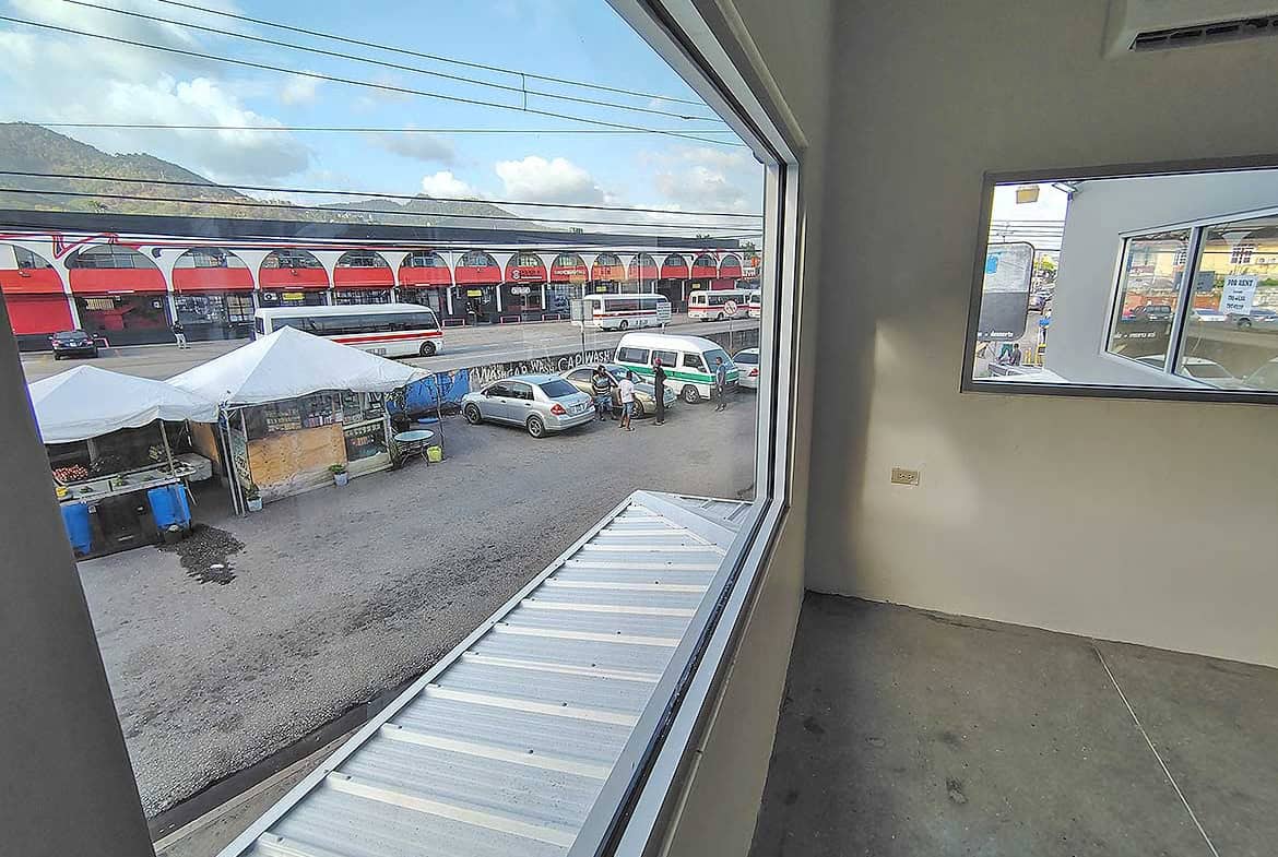 Cornerstone- View of Curepe train station and parking lot from inside office.