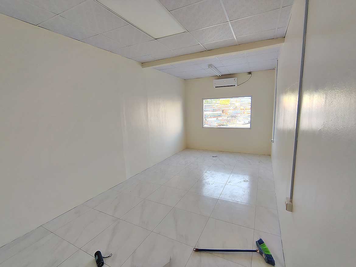 Commercial Space Interior in Curepe Cornerstone- Empty commercial room with white walls and window in Curepe.