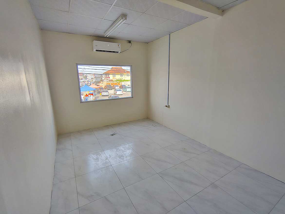 Commercial Space in Curepe Cornerstone- Empty commercial room with window and air conditioning unit in Curepe.