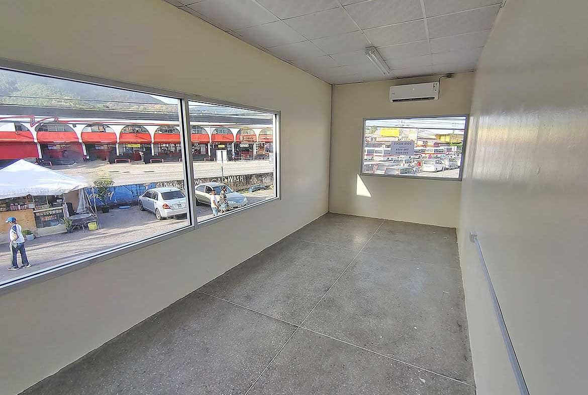Cornerstone- Empty commercial space with large windows in Curepe, Trinidad.