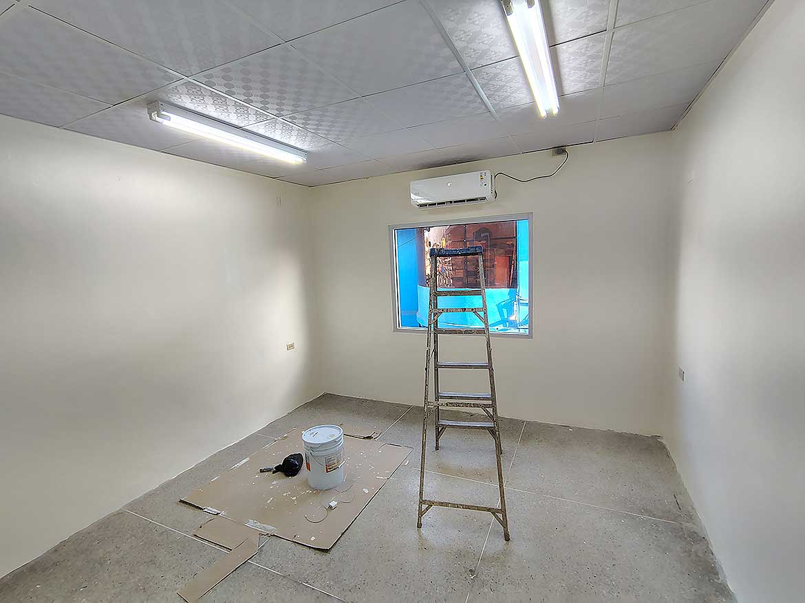 Commercial Space Interior in Curepe Cornerstone- Empty commercial room with ladder and construction tools in Curepe.