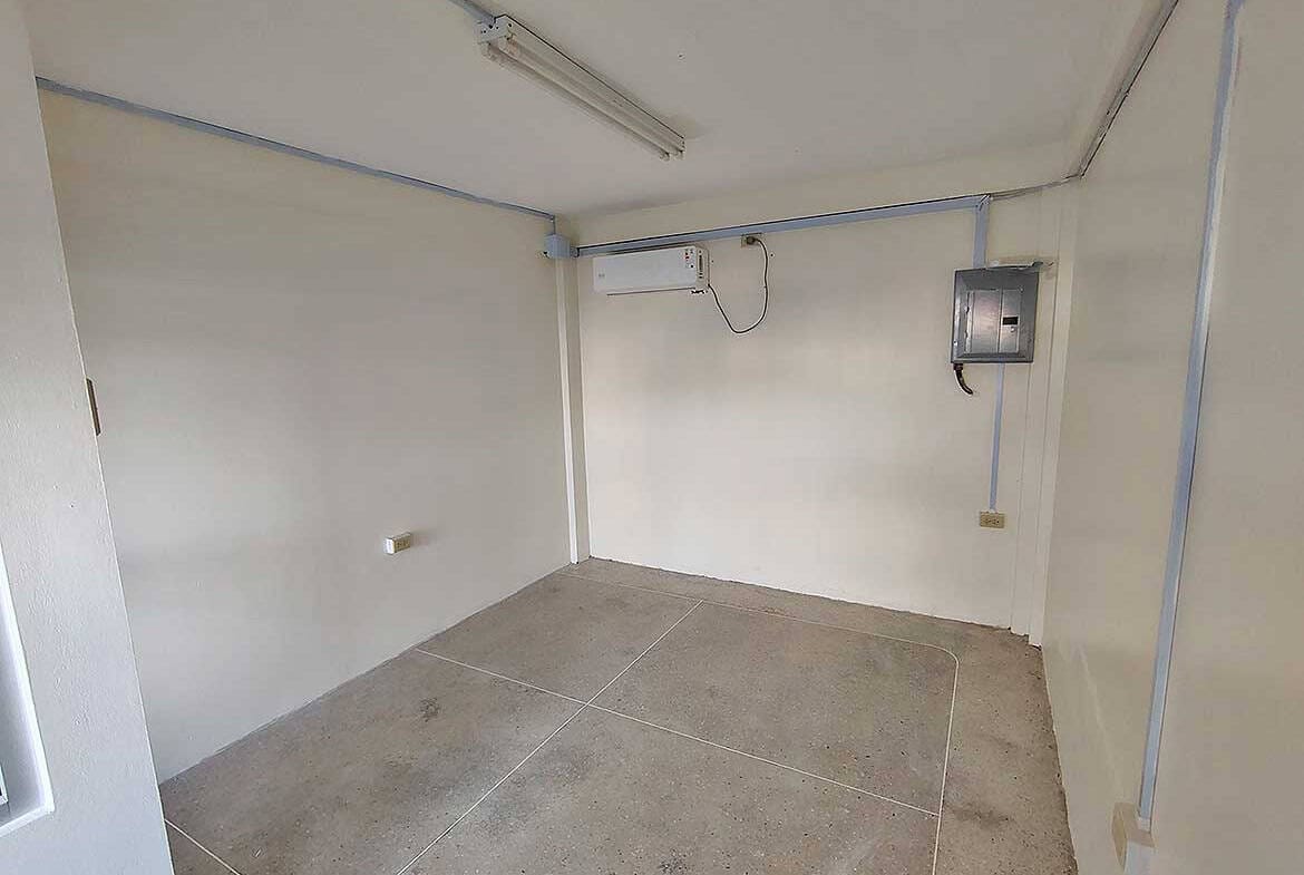 Cornerstone- Empty commercial room with electrical and air conditioning units in Curepe.