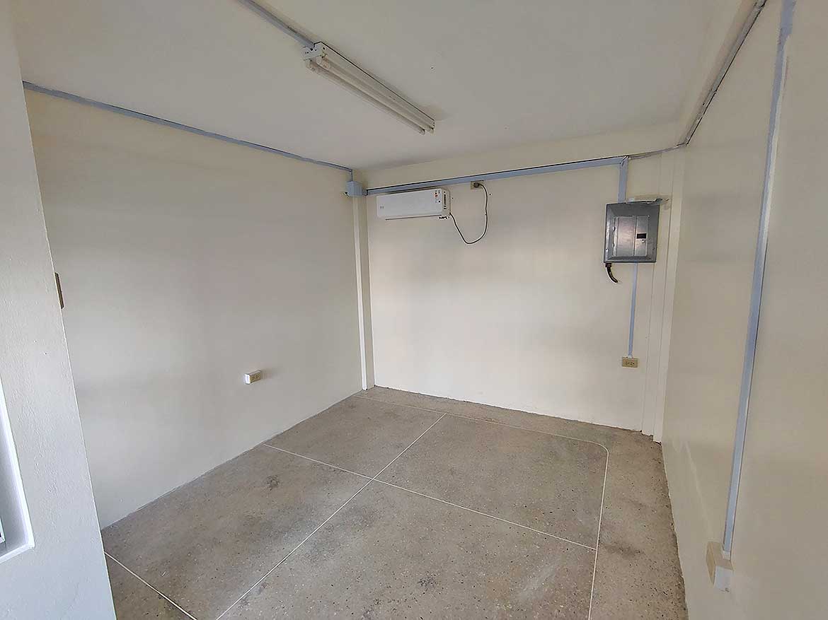 Commercial Space Interior in Curepe Cornerstone- Empty commercial room with electrical and air conditioning units in Curepe.