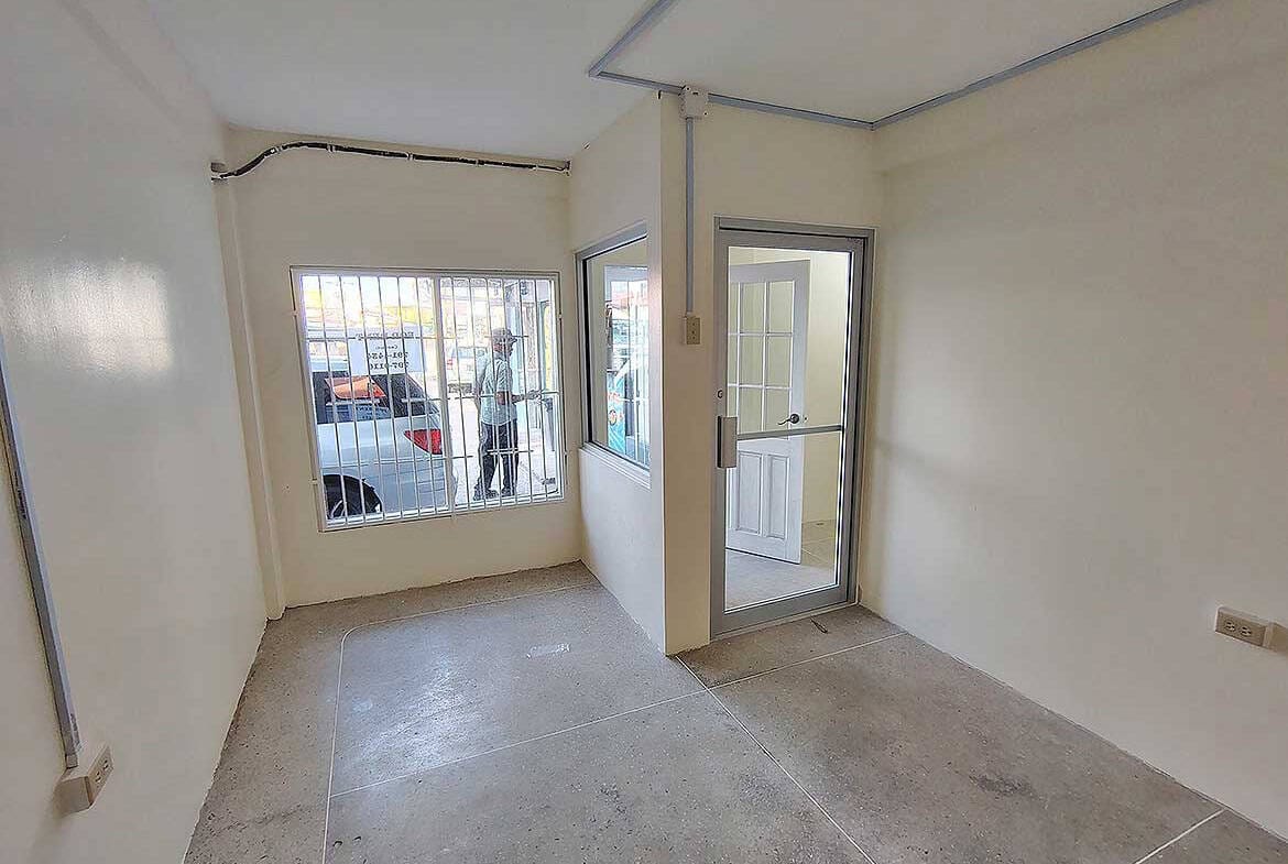 Cornerstone- Empty commercial space with large windows and glass door in Curepe.