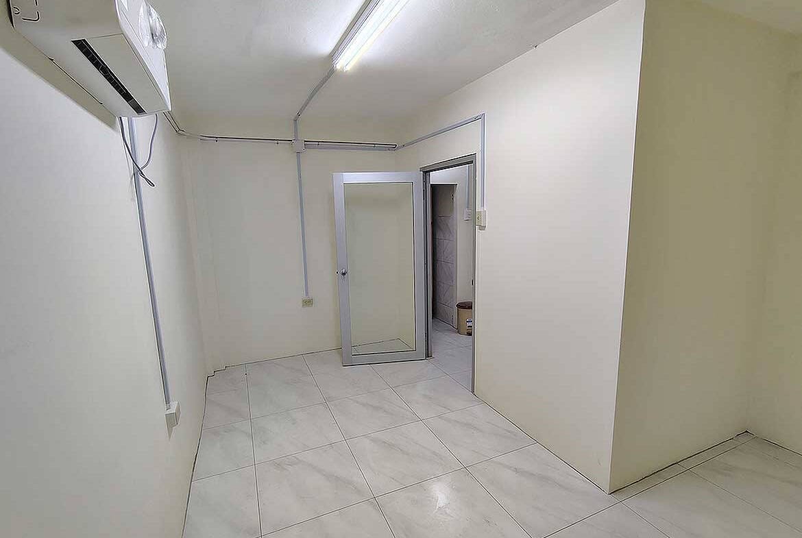 Empty commercial space interior with white walls and tiled floor in Curepe.