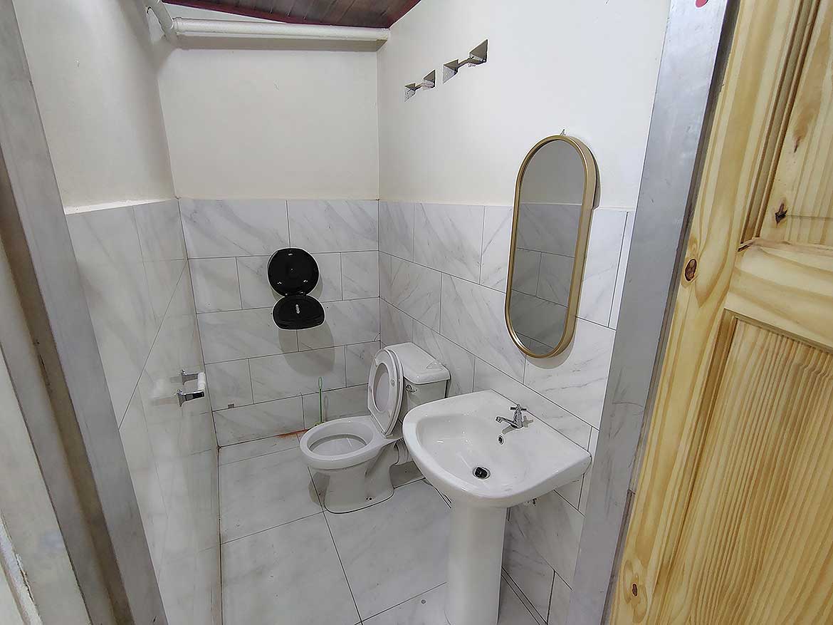 Commercial Space Restroom in Curepe Cornerstone- Small commercial restroom with toilet and sink in Curepe.