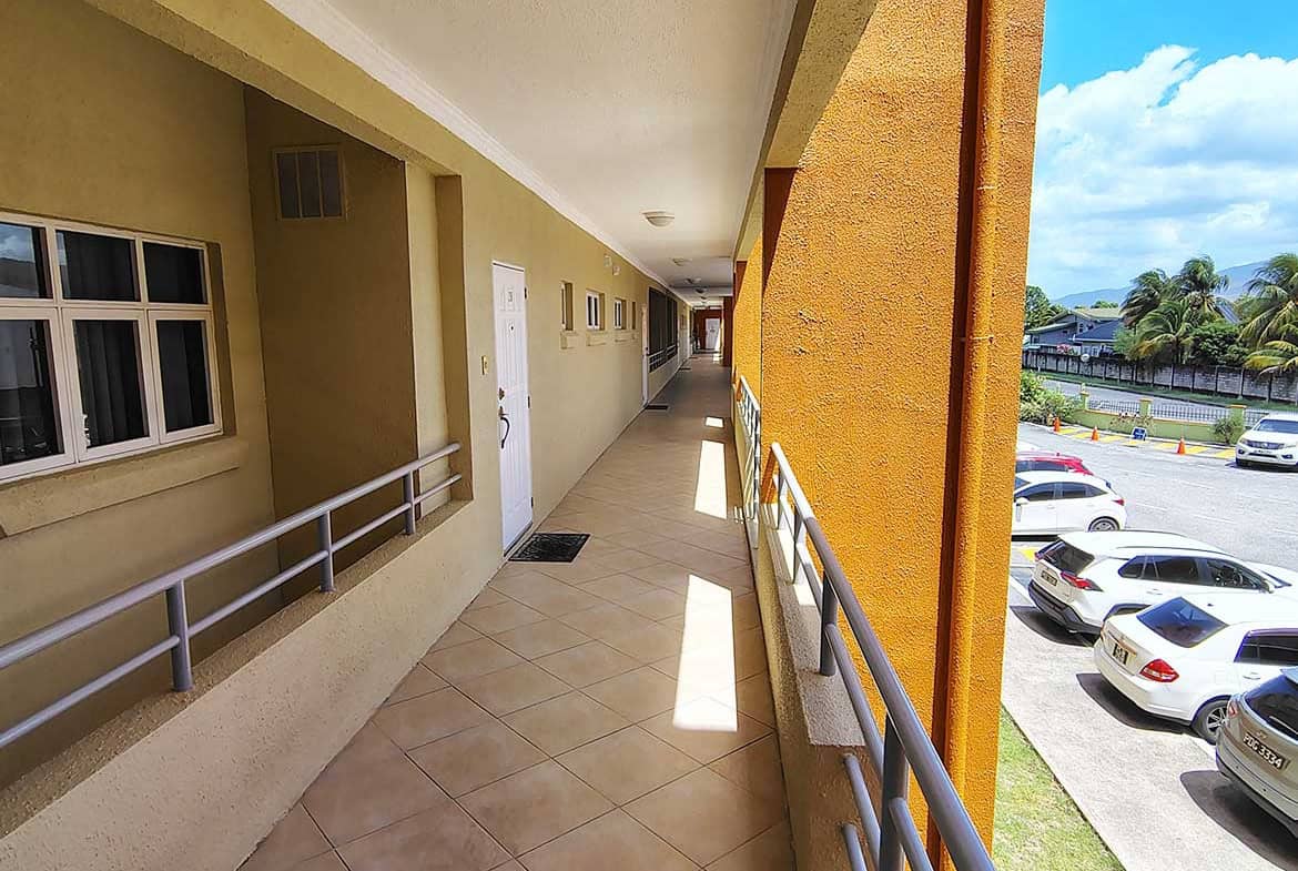 Balcony view at EastGate on the Greens with parking lot and landscape.