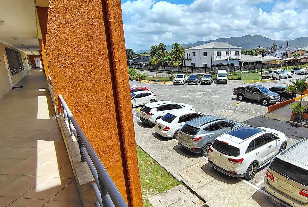 Parking lot view at EastGate on the Greens with cars and mountains in background.