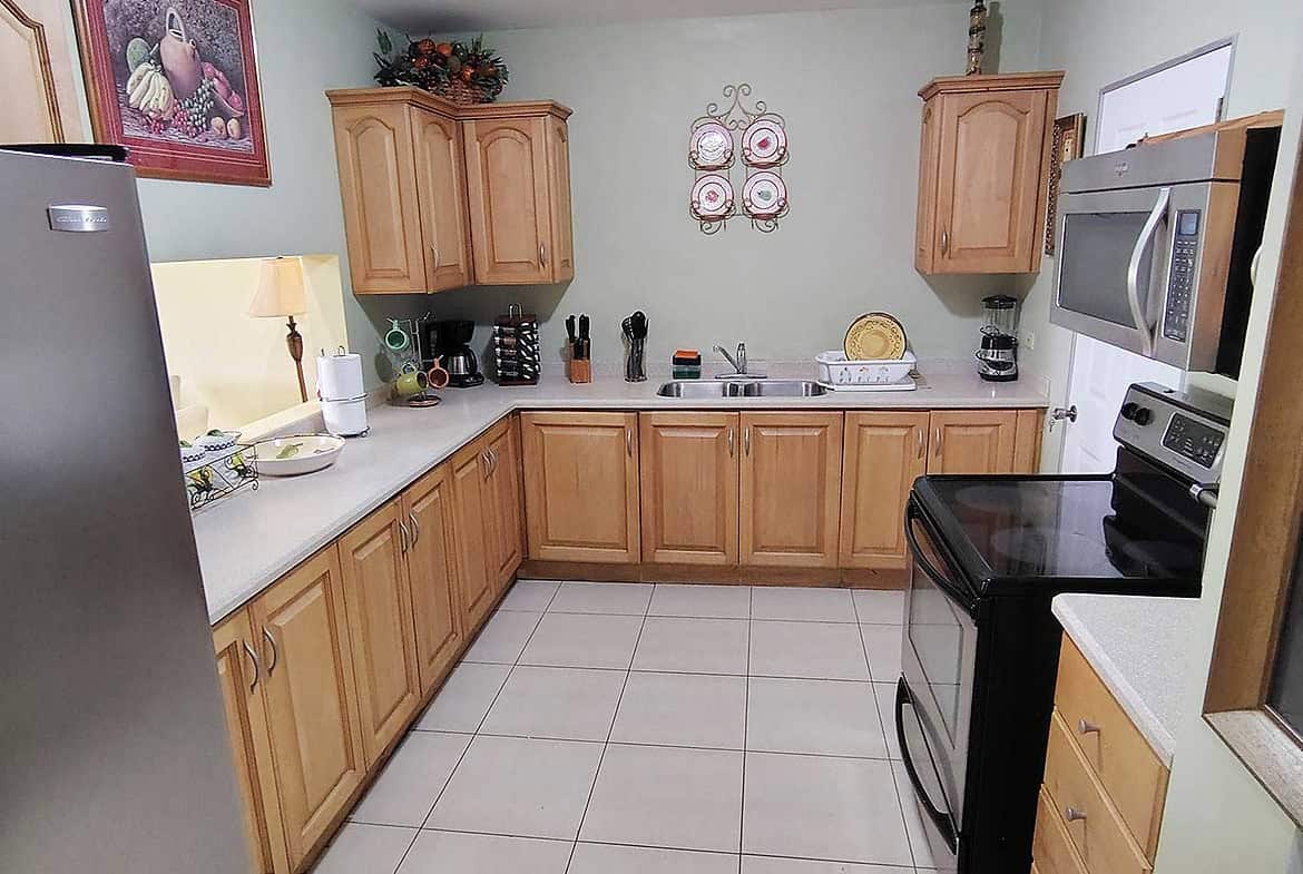 Spacious kitchen with wooden cabinets and modern appliances at EastGate on the Greens.