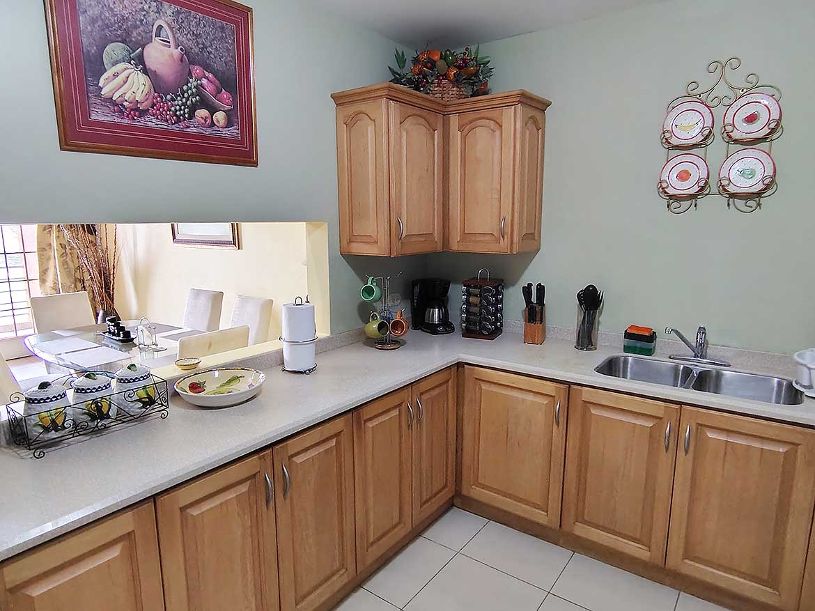 Cornerstone™ Kitchen in EastGate on the Greens Cozy kitchen with wooden cabinets and modern appliances at Cornerstone™.