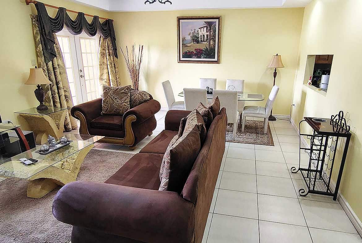 Spacious living room with sofas, dining area, and decorative curtains.
