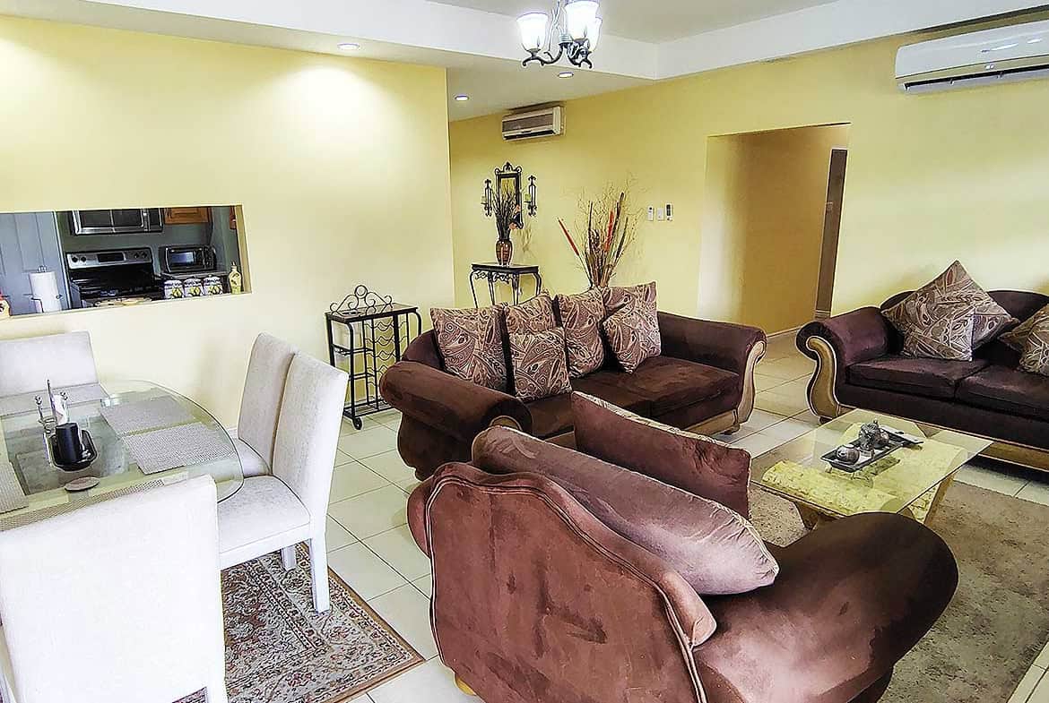 Spacious living room with sofas, dining area, and modern decor.