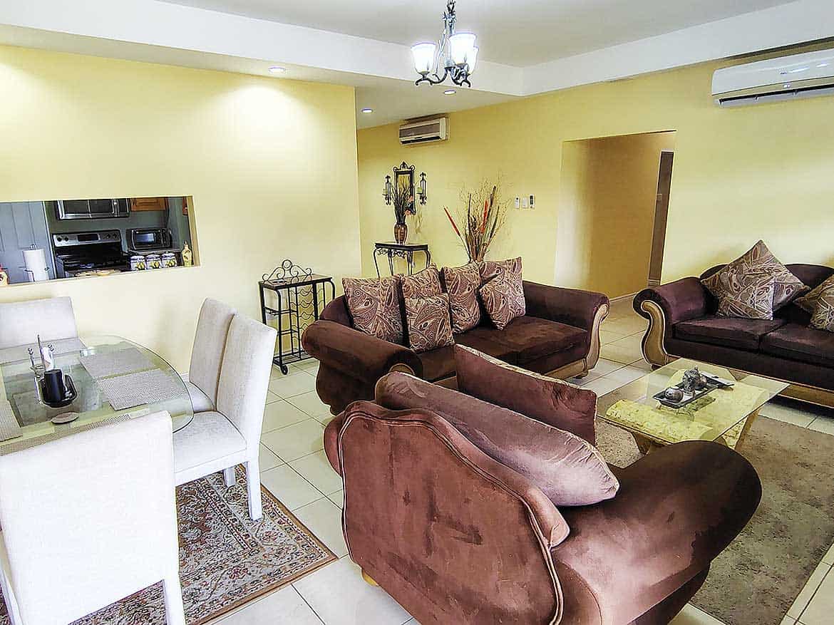 Living Room at EastGate on the Greens Spacious living room with sofas, dining area, and modern decor.
