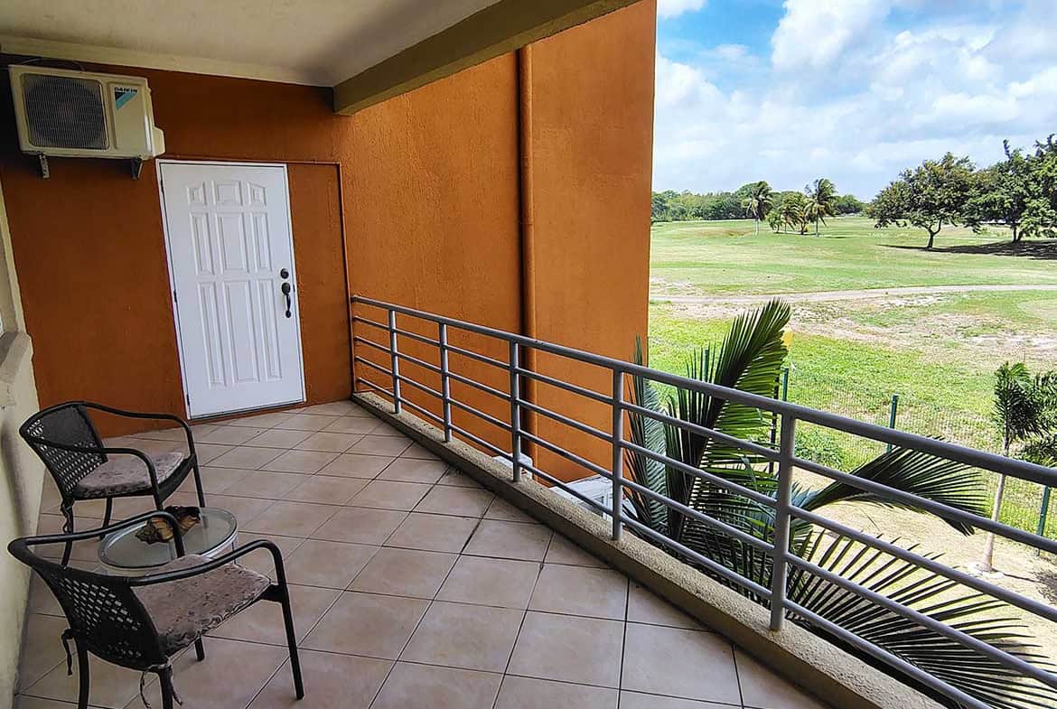 Balcony with chairs overlooking lush green golf course at EastGate on the Greens.
