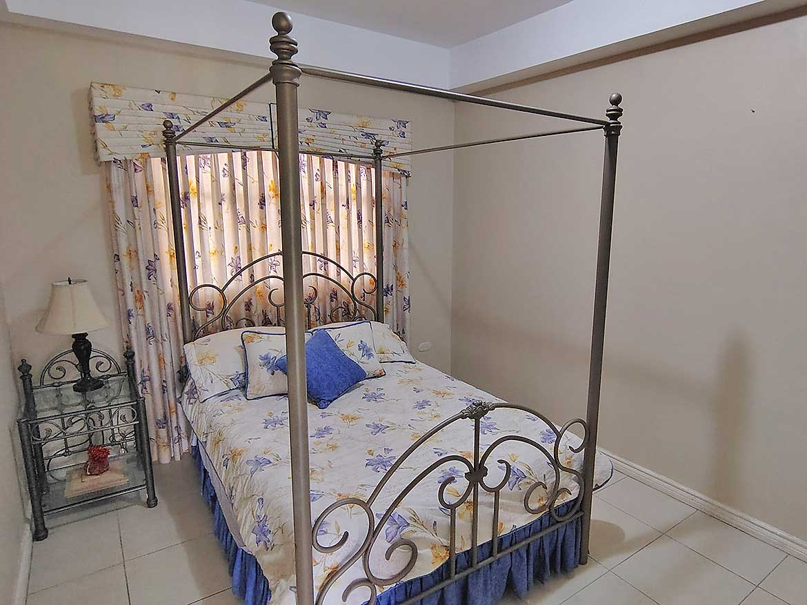 Elegant Bedroom with Four-Poster Bed Spacious bedroom featuring a decorative four-poster bed and floral curtains.