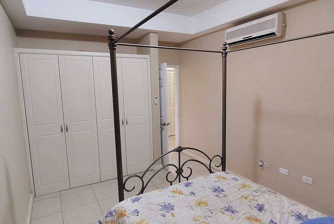 Modern bedroom with four-poster bed and air conditioning.