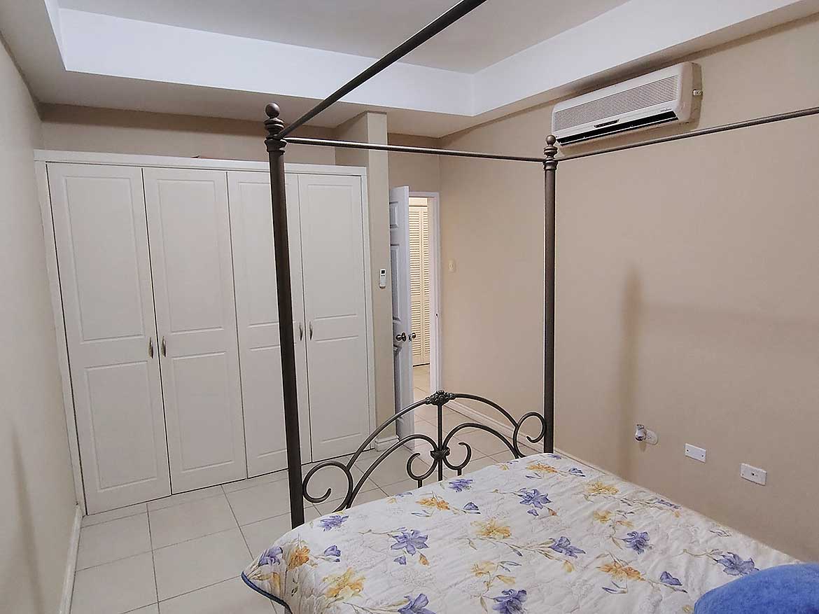 Cornerstone™ EastGate on the Greens Modern bedroom with four-poster bed and air conditioning.