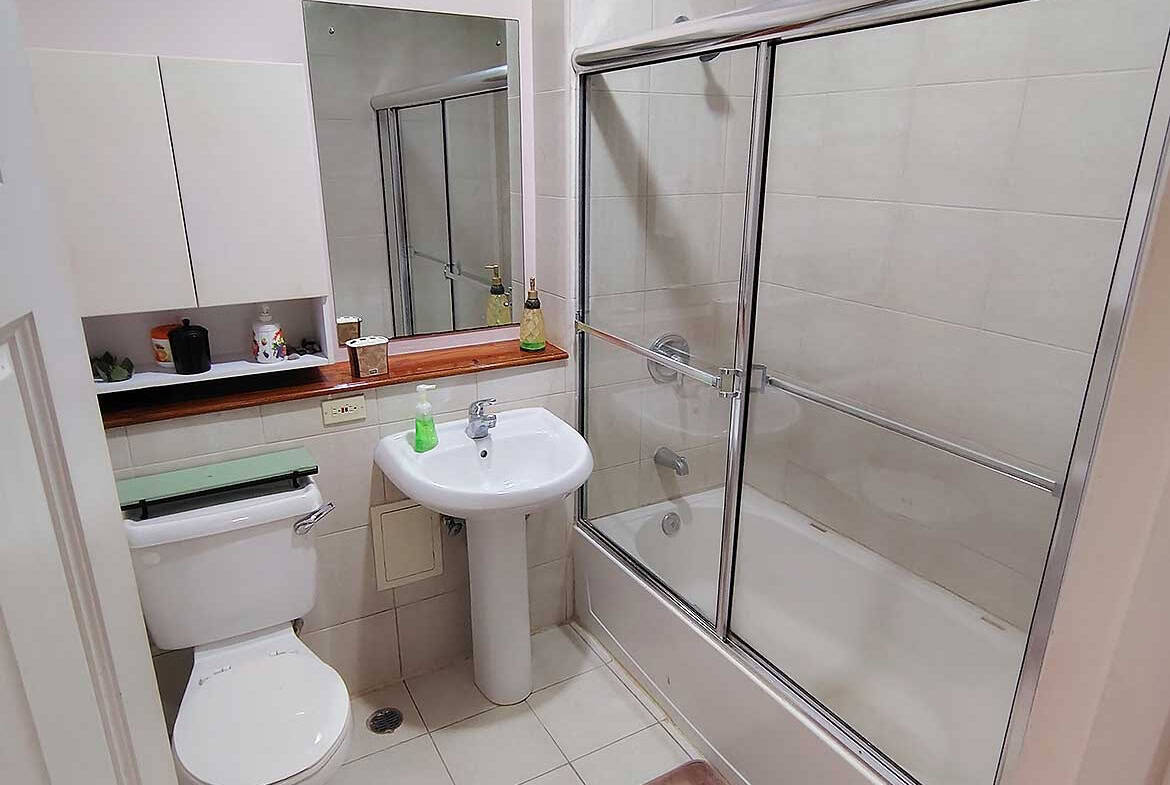 Clean bathroom with shower, toilet, and sink at EastGate on the Greens.