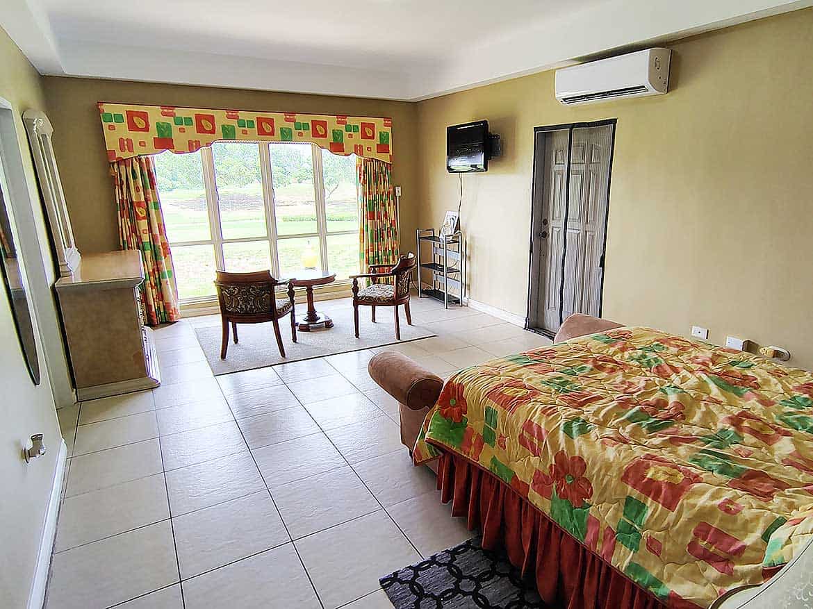 EastGate on the Greens Room with View Spacious hotel room with large window and colorful curtains at EastGate on the Greens.