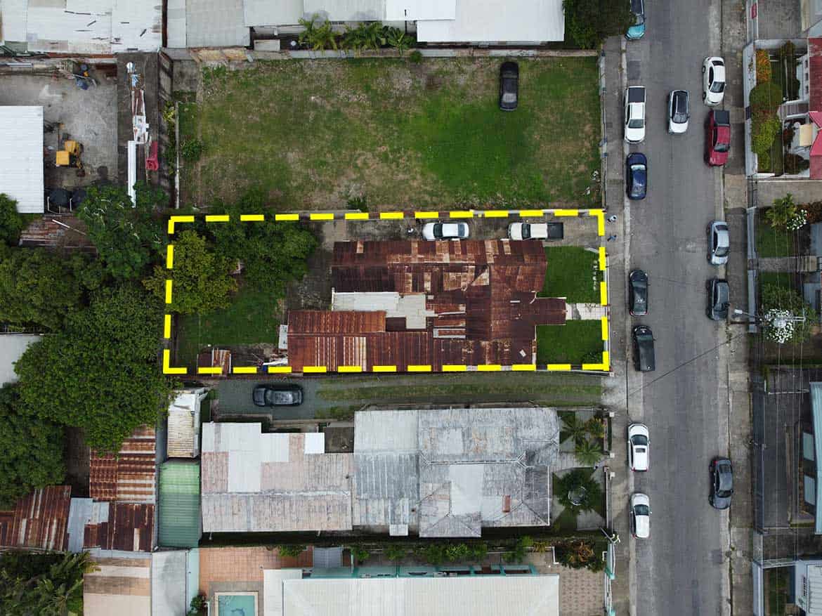 Cornerstone™ Property on Carlos Street Cornerstone- Aerial view of a property on Carlos Street, Woodbrook, with a yellow boundary outline.
