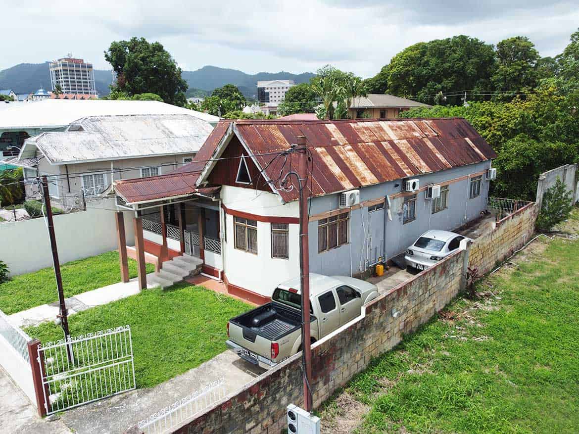 Cornerstone™ Residential Property in Woodbrook Cornerstone- Residential house on Carlos Street, Woodbrook with parking and greenery.
