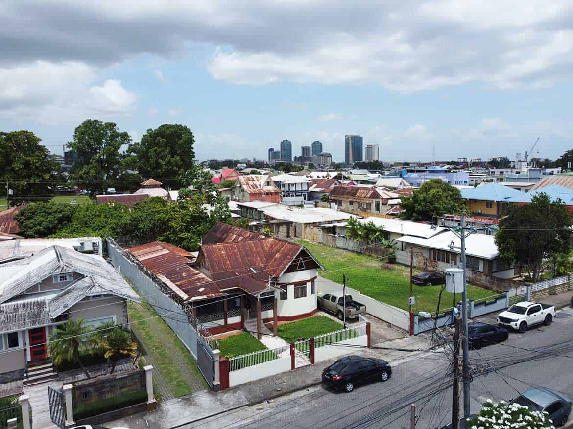 Cornerstone™ Residential Homes in Woodbrook Cornerstone- Residential homes on Carlos Street, Woodbrook with city skyline in background.