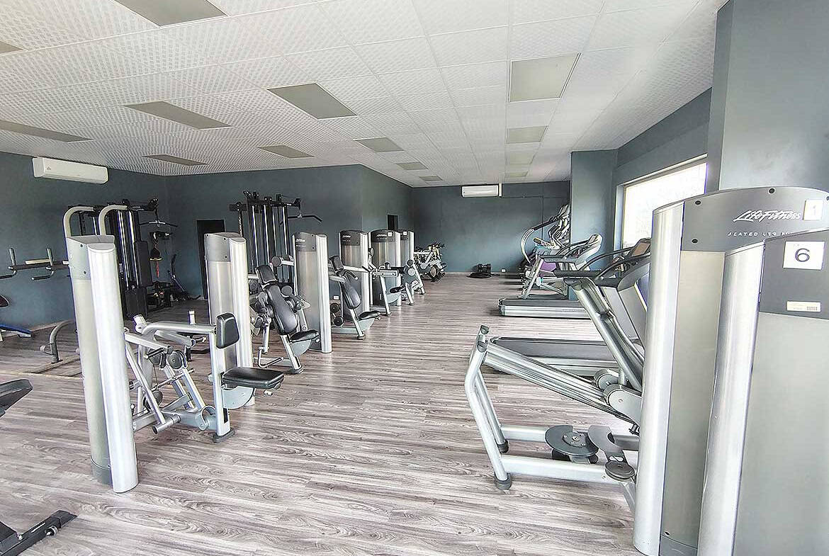 Modern gym with cardio and strength equipment at Ella Vista Gardens.
