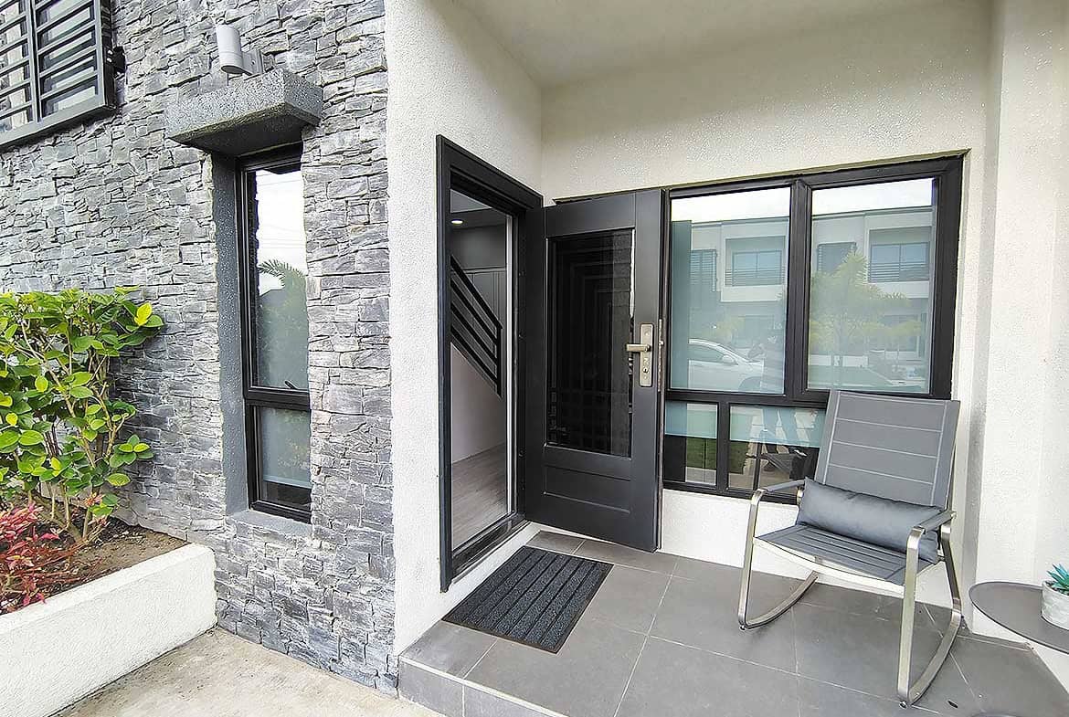 Modern apartment entrance with stone wall and seating area.