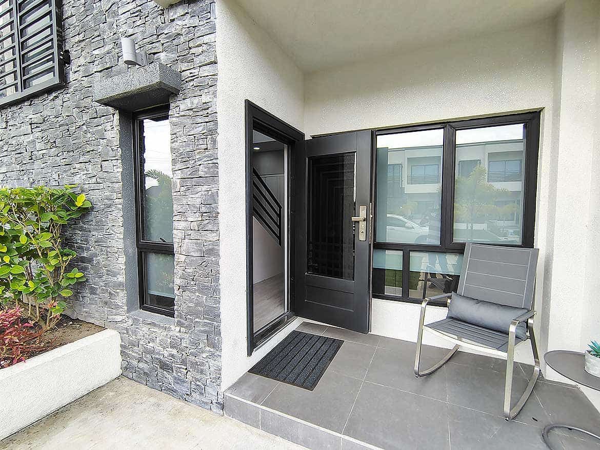 Ella Vista Gardens Entrance Modern apartment entrance with stone wall and seating area.