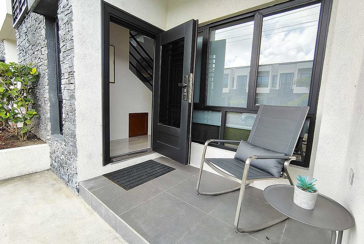 Modern entrance with black door and large window at Ella Vista Gardens.