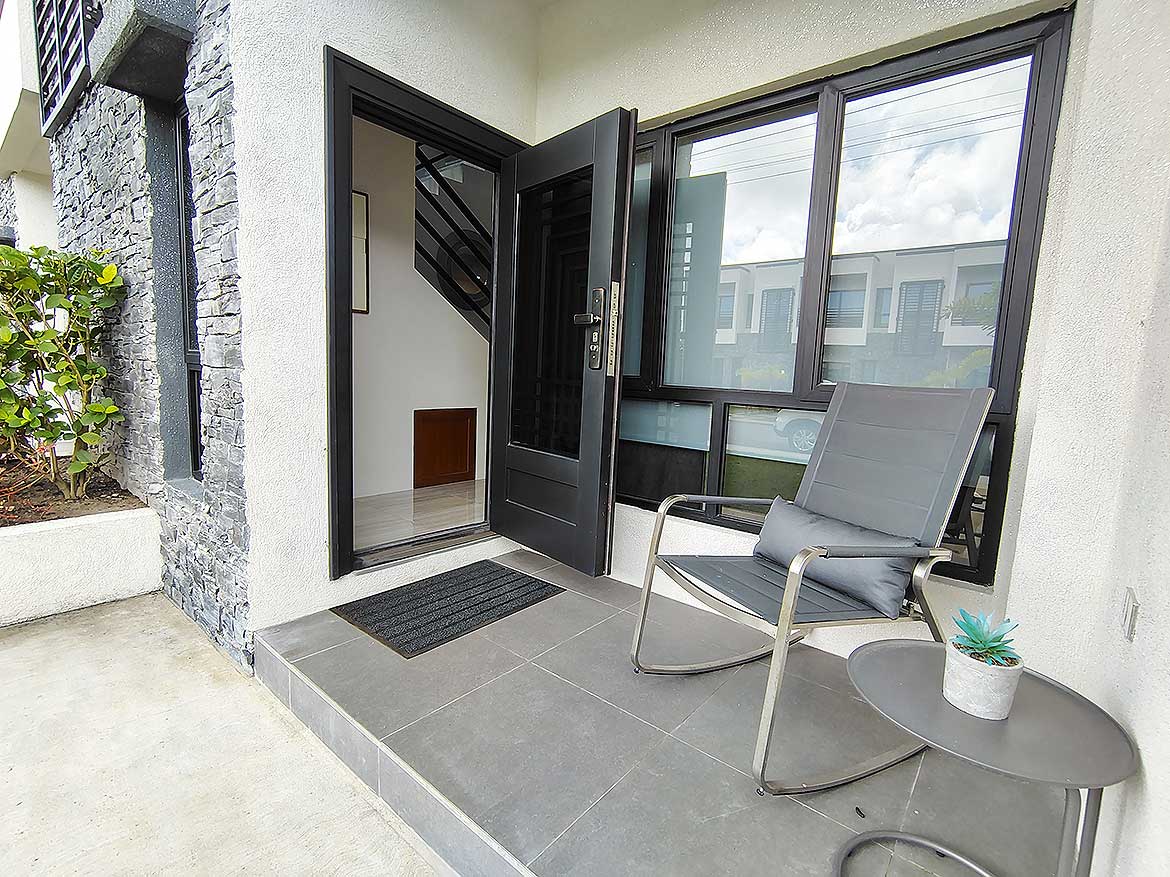 Cornerstone™ Ella Vista Gardens Entrance Modern entrance with black door and large window at Ella Vista Gardens.