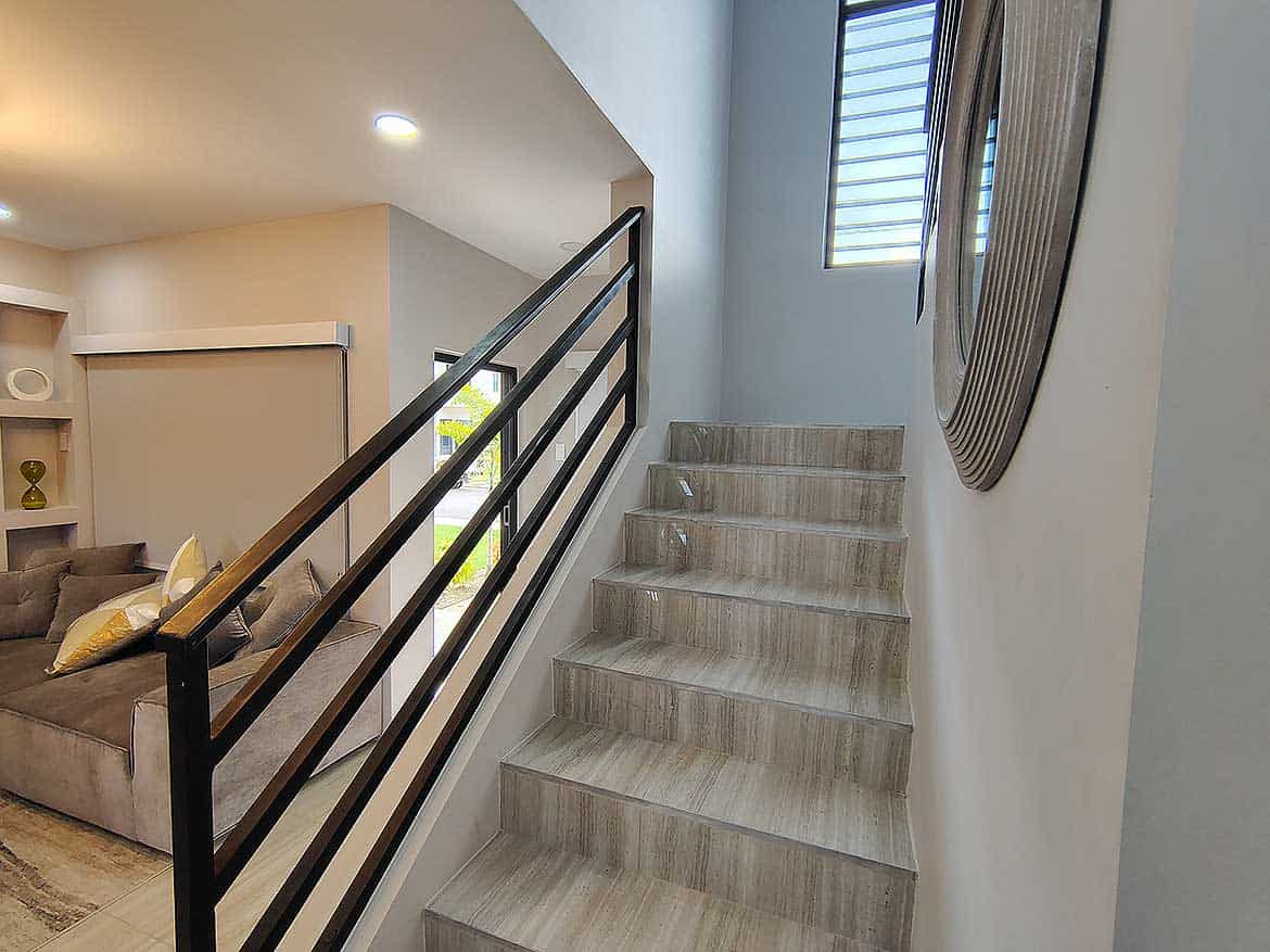 Interior Staircase at Ella Vista Gardens Modern interior staircase with wooden steps and black metal railing in Ella Vista Gardens.