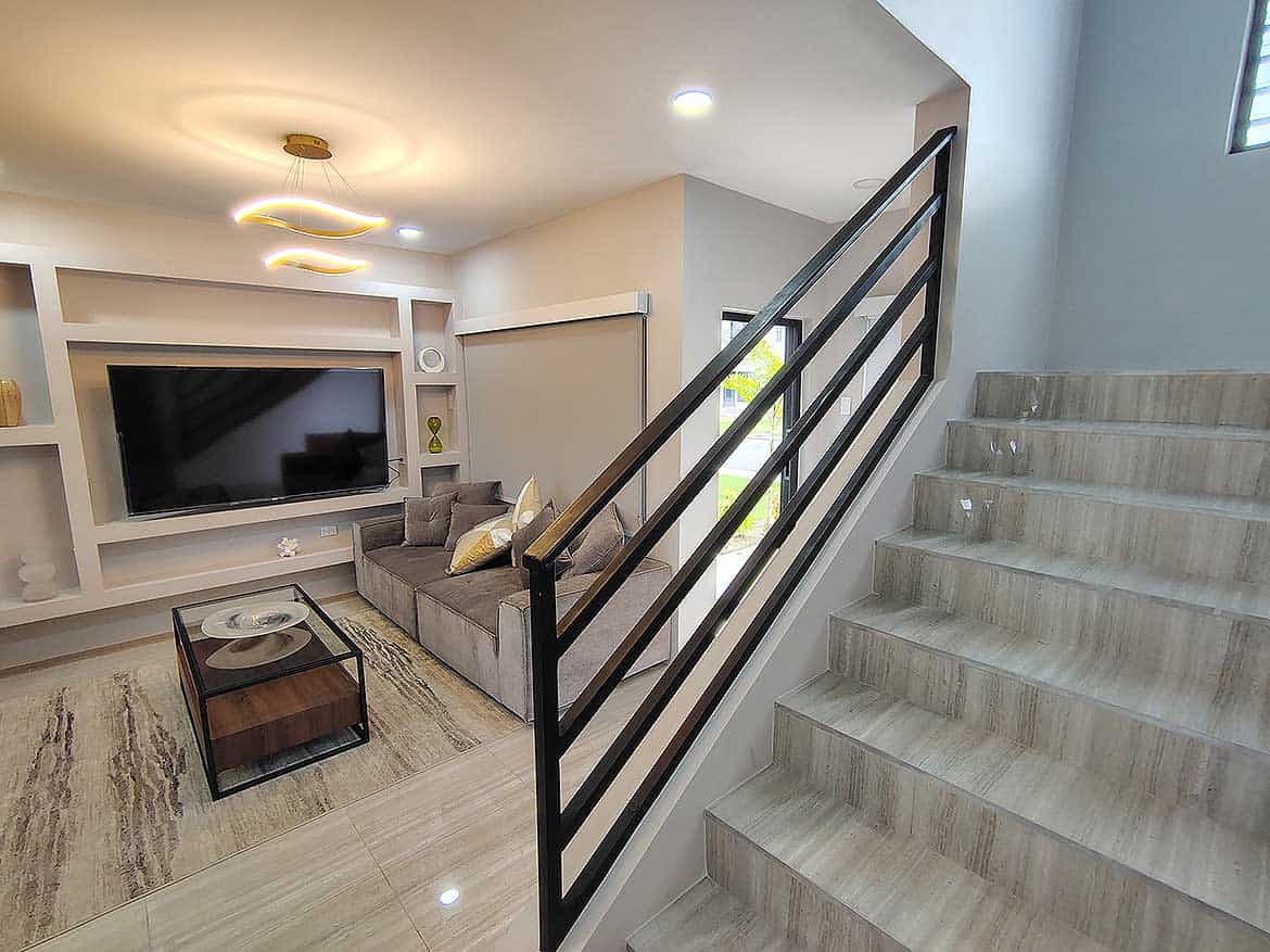 Modern Living Room at Ella Vista Gardens Contemporary living room with TV, sofa, and staircase at Ella Vista Gardens.