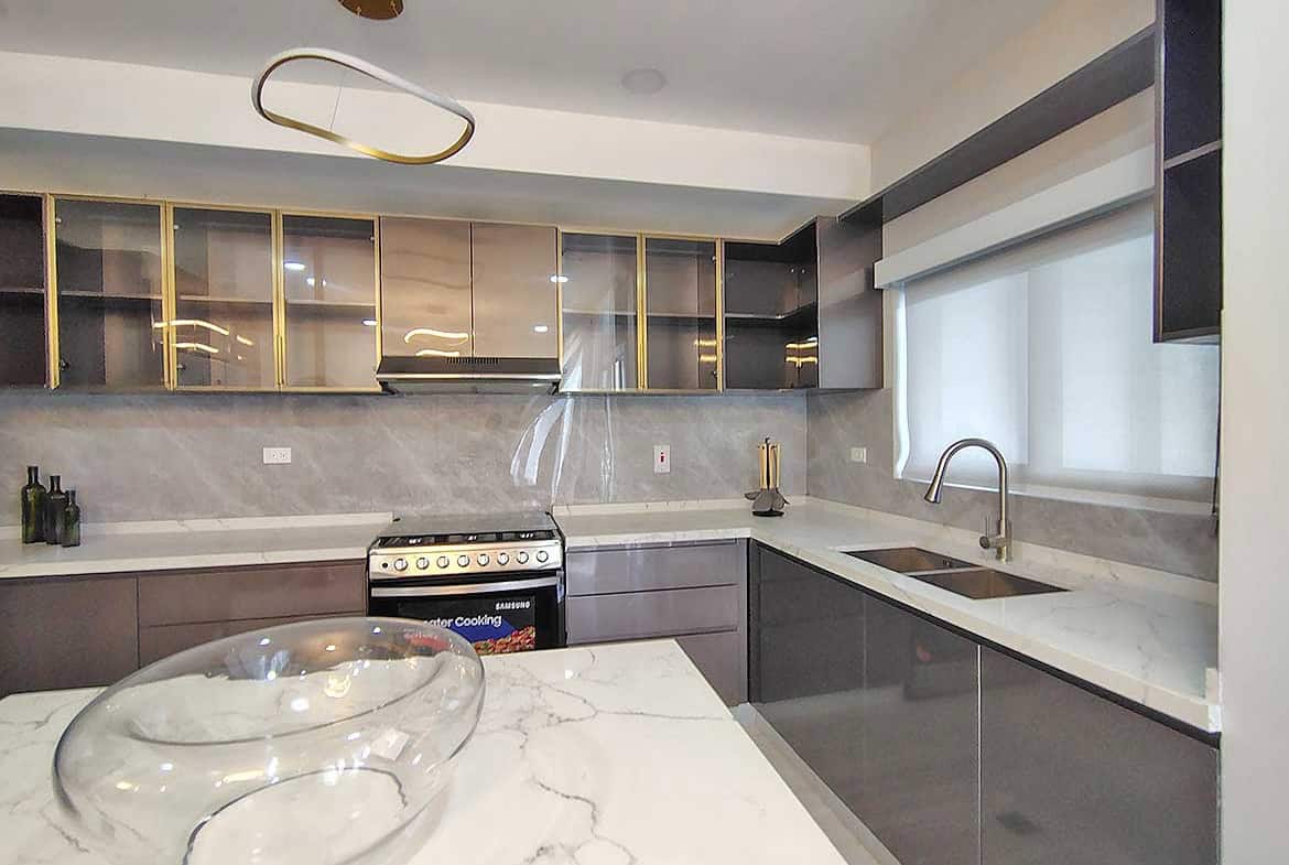 Contemporary kitchen with marble countertops and sleek cabinetry at Ella Vista Gardens.
