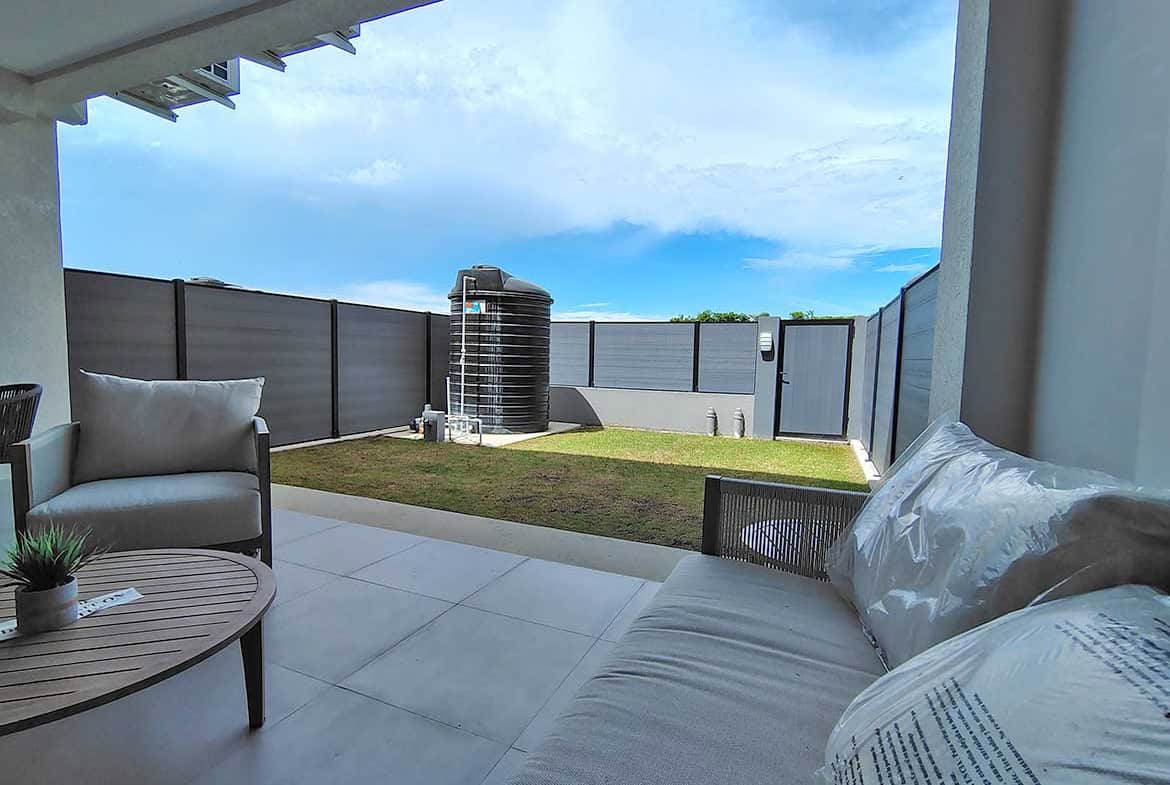 Modern outdoor patio with view of backyard and sky at Ella Vista Gardens 8B.