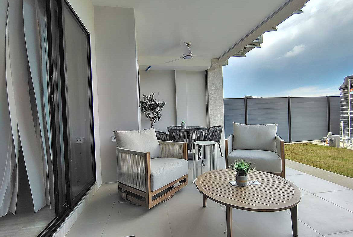 Modern balcony with outdoor seating and city view at Ella Vista Gardens.