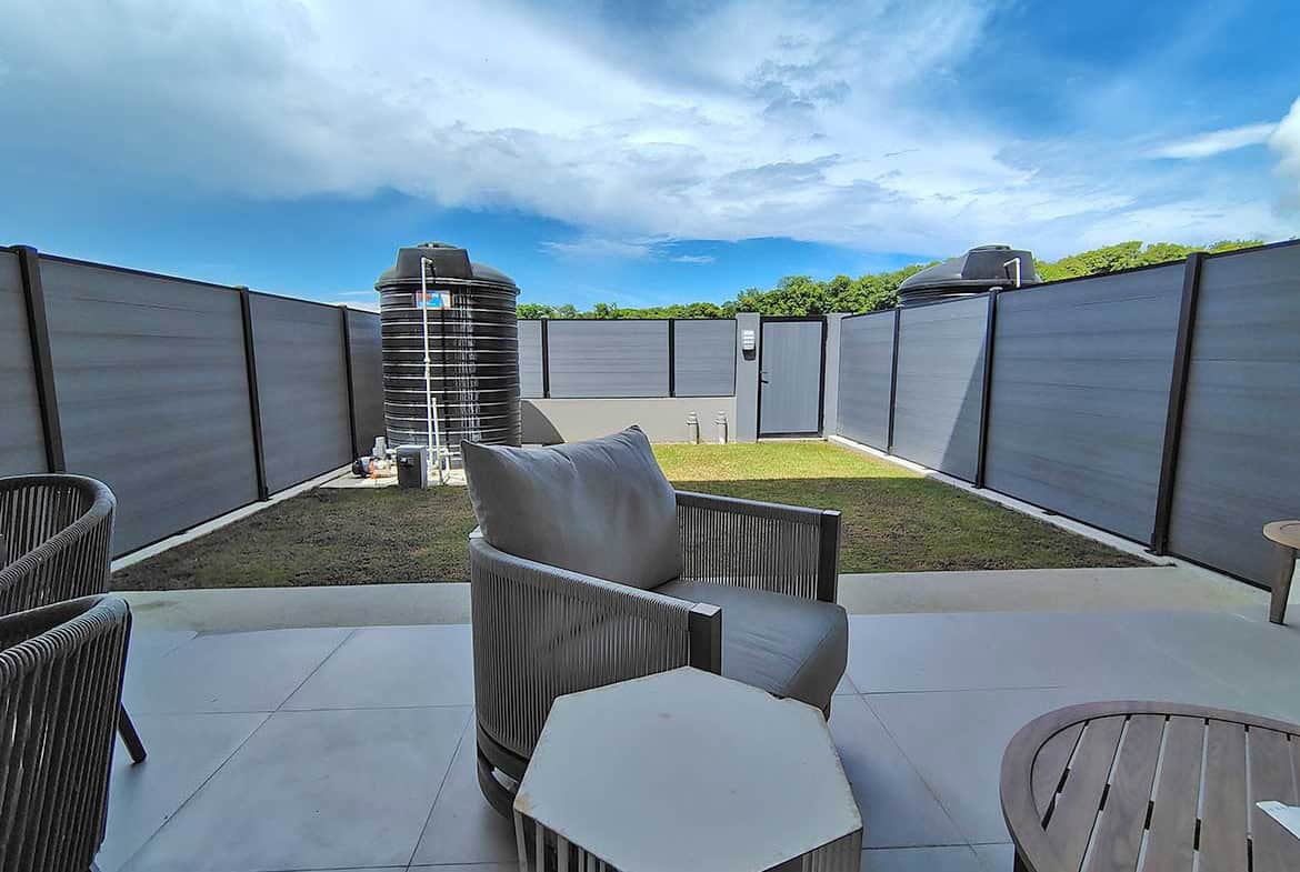 Modern outdoor patio with seating and water tanks at Ella Vista Gardens.