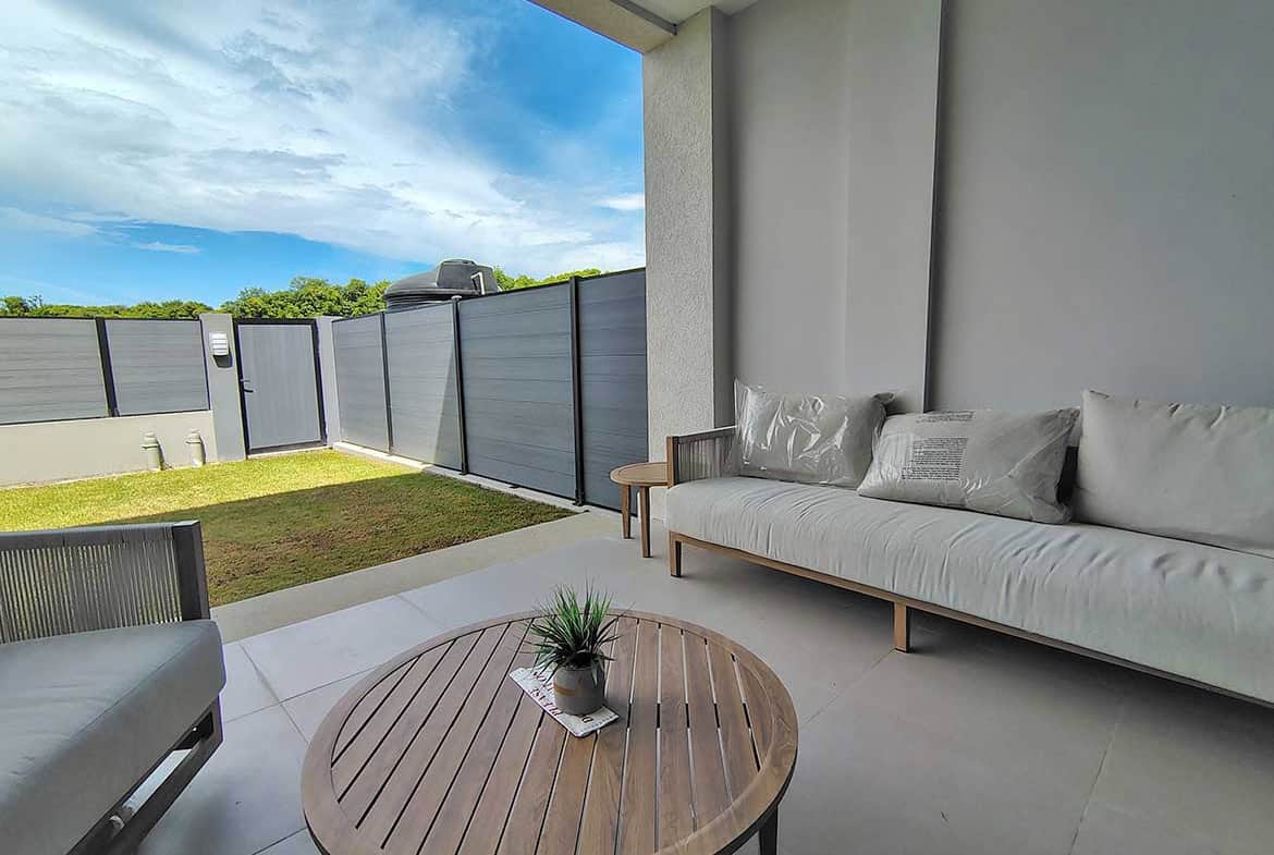 Modern balcony with outdoor seating and garden view at Ella Vista Gardens.