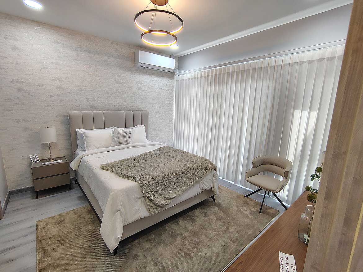 Elegant Bedroom at Ella Vista Gardens Modern bedroom with large window, cozy bed, and stylish decor at Ella Vista Gardens.